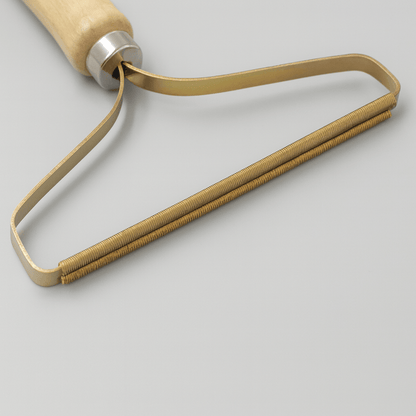 Portable Pet Hair & Lint Remover – Manual Brush for Clothes and Furniture with wooden handle and metal lint removal head.