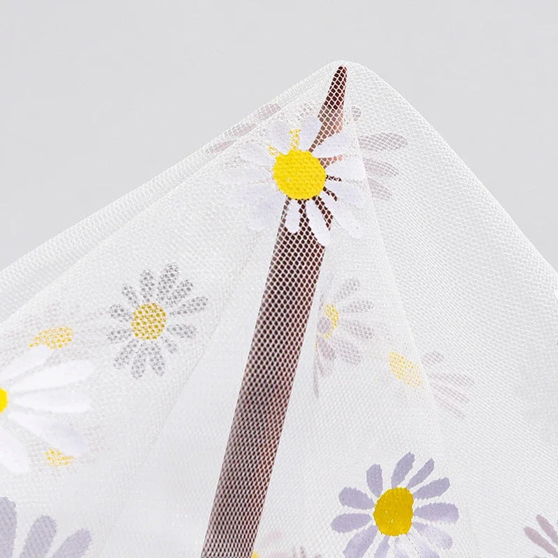 Close-up of floral-patterned mosquito netting for baby stroller sunshade and bug protection.